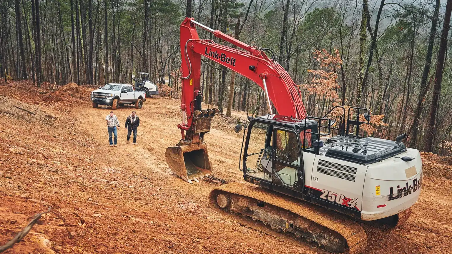 Photo of Ryan Dempsey and Austin Taylor with an excavator